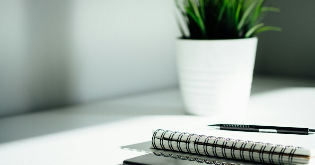 pen, notebook, and smartphone on table