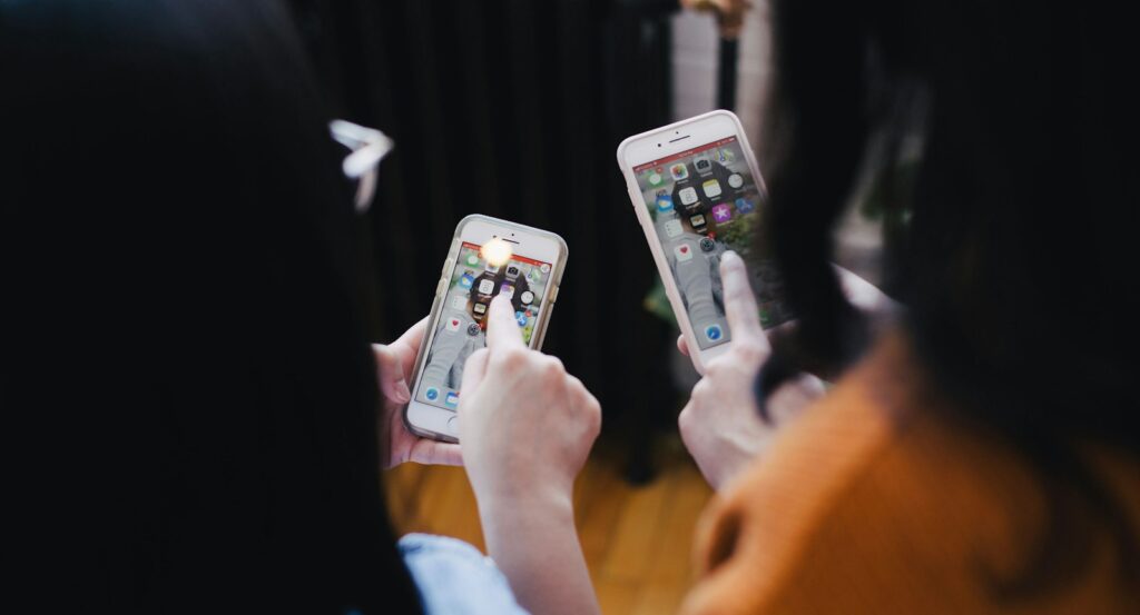 two women operating smartphone