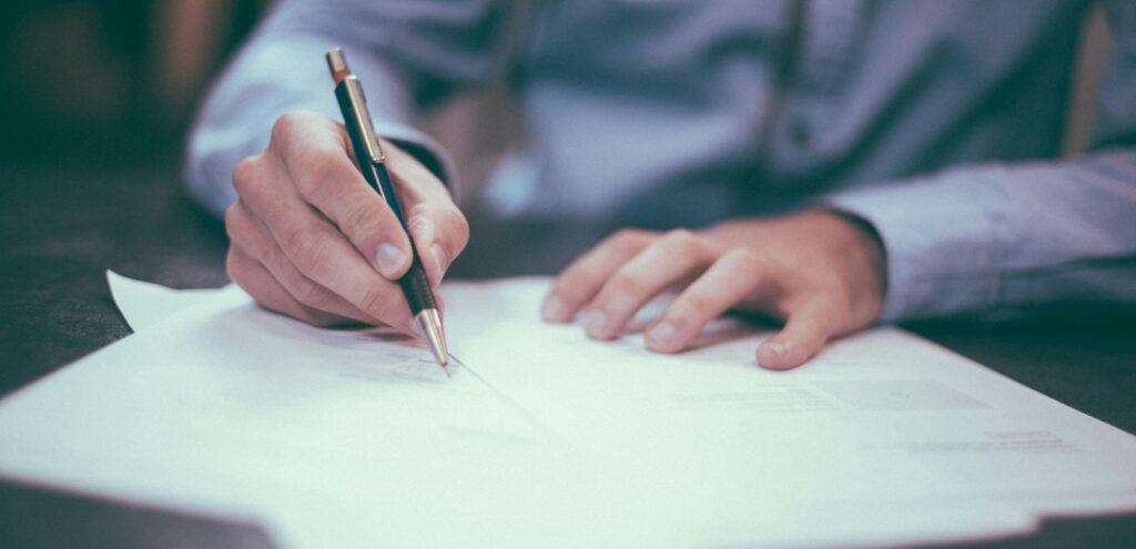 man writing on paper